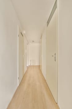 an empty room with white walls and wood flooring on the right side of the room, there is a door leading to another