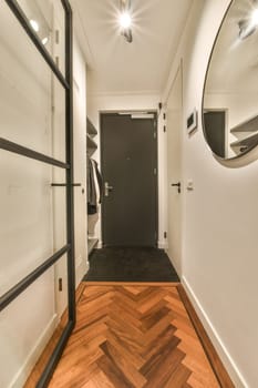 a long narrow hallway with wood flooring and black trim around the door, leading to an open closet space