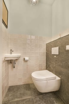 a small bathroom with a toilet and sink in the corner, all made up of white marble tiles on the walls