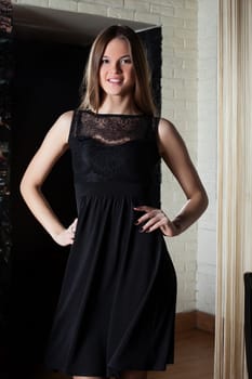 Smiling young girl posing in black cocktail dress, close-up