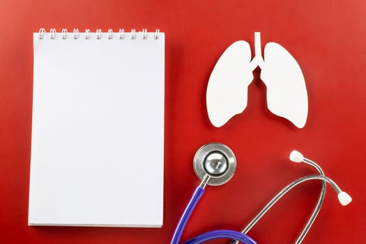 World TB Day. Top view lungs paper symbol, medical stethoscope and notebook paper on red background, lung cancer awareness, copy space concept of world tuberculosis day, banner background