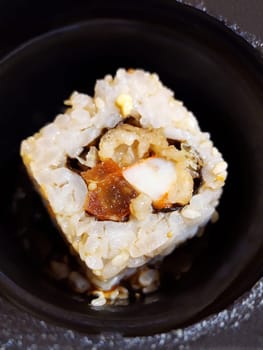 Appetizing sushi roll close-up on a black background.