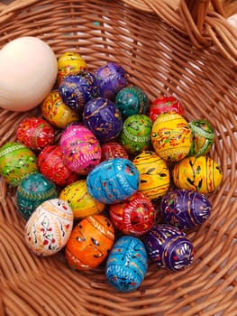 On the eve of Easter, holiday decorations in the form of colorful Easter eggs in a basket close-up.