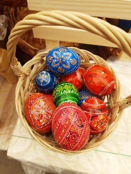 On the eve of Easter, holiday decorations in the form of colorful Easter eggs in a basket close-up.