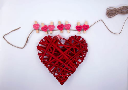 Red hearts and a big straw heart on a white background close-up.