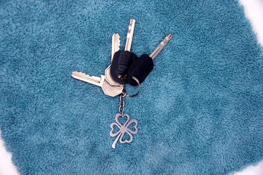 A bunch of keys from the apartment with a keychain on a blue background.