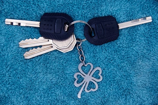 A bunch of keys from the apartment with a keychain on a blue background.