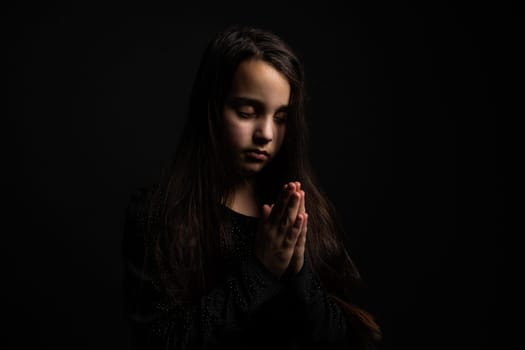 Portrait of a beautiful little baby girl praying. Facial expression. Kid and emotions. Faith and the Bible concept.