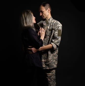 military man and his wife on a black background.