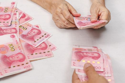 Chinese Senior woman counting money for payment