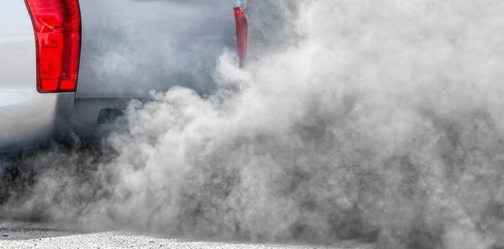 Air pollution from vehicle exhaust pipe on road