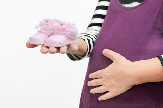 Single mom pregnancy holding baby shoes, close up