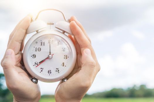 Selective focus of alarm clock with nature bokeh background. lifestyle  productive life concept.