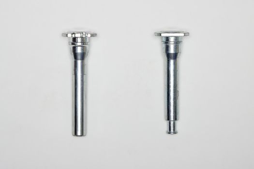 Two metal fingers, machine repair parts. A set of spare parts for servicing the braking system of a vehicle. Details on white background, copy space available.