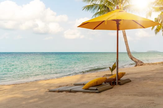 Umbrella and chair at tropical summer beach background with copy space blue sky.