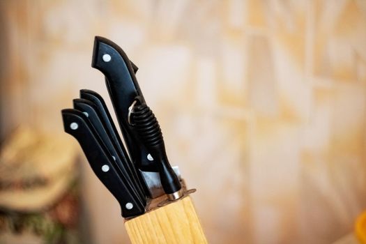 Black kitchen knives in the stand close up, copy space