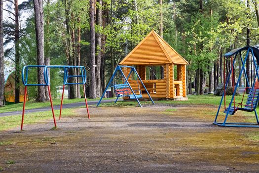 Playground in the park among the trees in summer