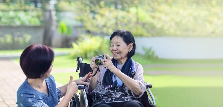 daughter looking after elderly mother in backyard