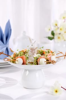 Appetizer quail egg stuffed with alfalfa sprouts with a slice of salmon, on a wooden skewer. Buffet serving for the Easter table.