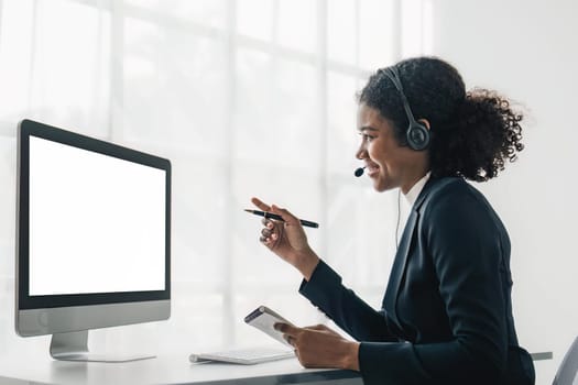 Portrait of happy smiling female customer support phone operator at workplace. Smiling beautiful African American woman working in call center.