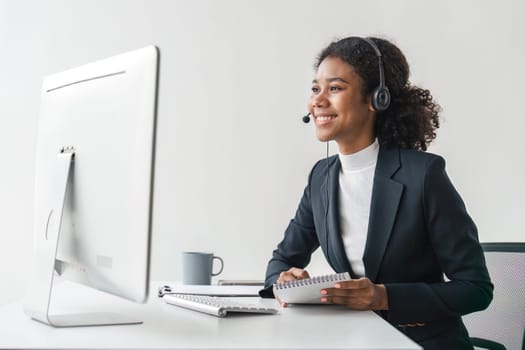 Portrait of happy smiling female customer support phone operator at workplace. Smiling beautiful African American woman working in call center.