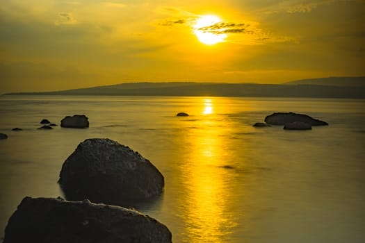 Rocks on the beach during sunrise in Banyuwangi, Indonesia. Long exposure photography. Defocused.