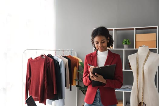 Female stylist Successful Fashion Business. Portrait of Smiling Black Designer stylish standing and working at fashion studio. Portrait of fashion designer in office..