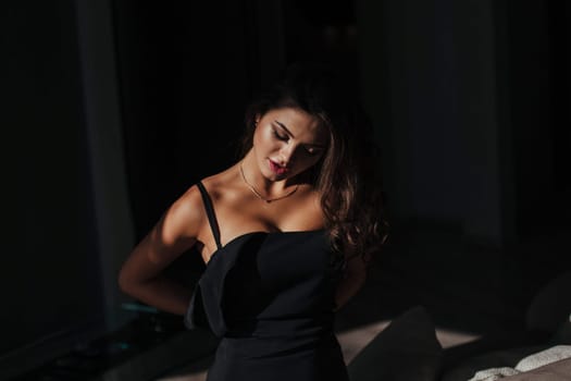 beautiful woman takes off black classic dress. concept of home and comfort.