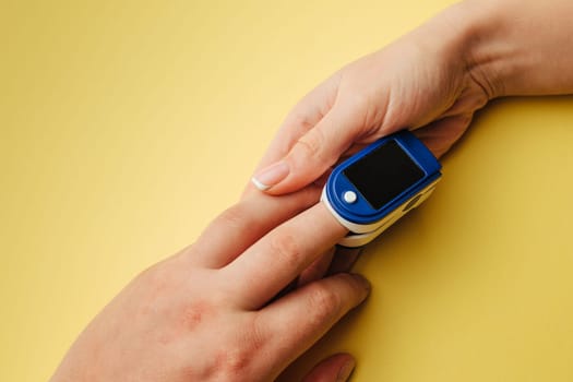 Diagnosis of coronavirus. The doctor measures the saturation of blood oxygen with a special device.