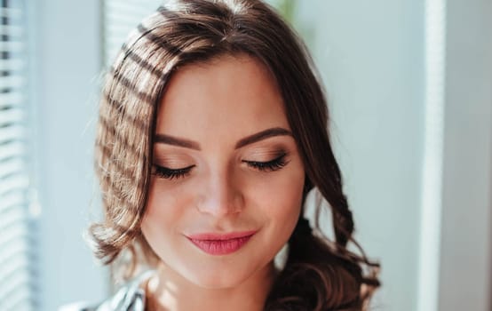 Portrait photo of a beautiful young brunette girl with her eyes closed who gets pleasure.