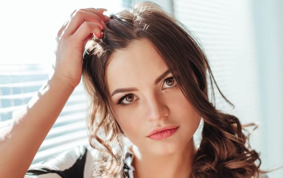 beautiful brunette with wavy hair looks thoughtfully and scratches her head. close-up.