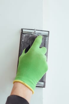 a man's hand in a green glove is grinding the wall