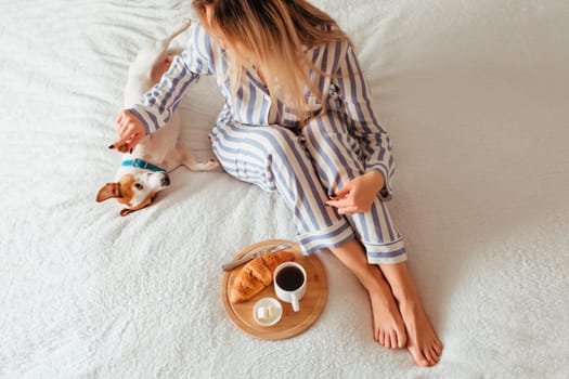 morning breakfast in bed croissant and coffee. next to her is a woman in pyjamas . top view