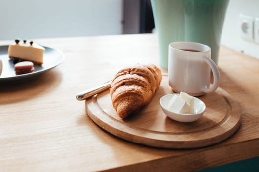 a croissant of coffee and butter sits on the windowsill . the concept of a rich breakfast