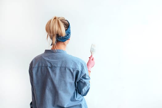 girl paint the wall with a brush.