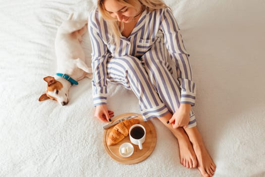 morning breakfast in bed croissant and coffee. next to her is a woman in pajamas . top view