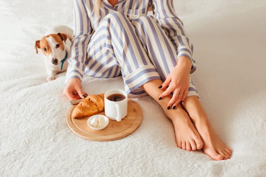 morning breakfast in bed croissant and coffee. next to her is a woman in pajamas . top view