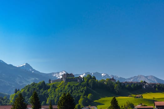 Castle of Gruyeres among forest and greend meadows in Haut-Intyamon, Gruyere, Fribourg, Switzerland.