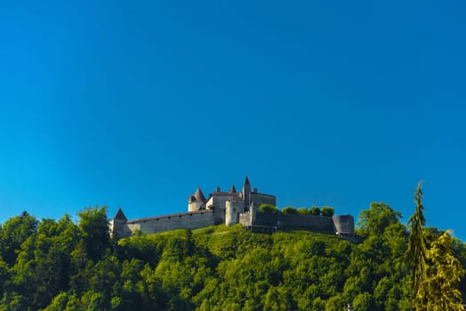 Castle of Gruyeres among forest and greend meadows in Haut-Intyamon, Gruyere, Fribourg, Switzerland.