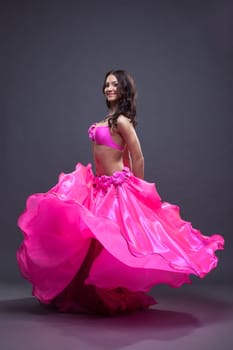 Full length portrait of pretty dancer performing oriental dance