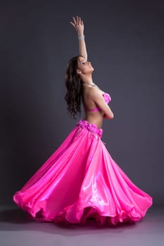 Full length portrait of pretty dancer performing oriental dance