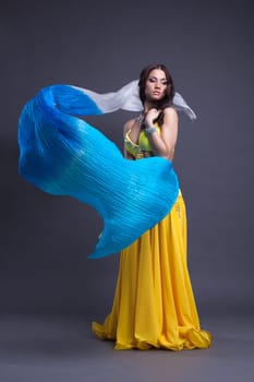 Full length portrait of pretty dancer in yellow oriental costume with veer
