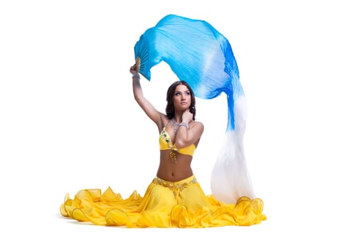 Pretty young woman in oriental costume with flying veil performing arabic dance. Isolated on white