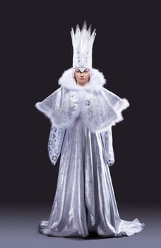 portrait of serious girl stand in ice queen carnival costume