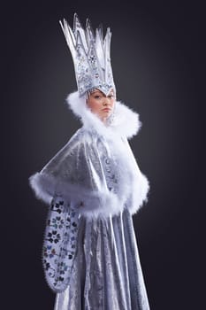 portrait of serious girl stand in ice queen carnival costume