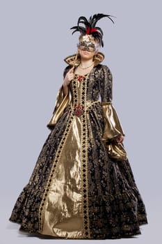 Full length portrait of young girl in carnival costume middle age with mask