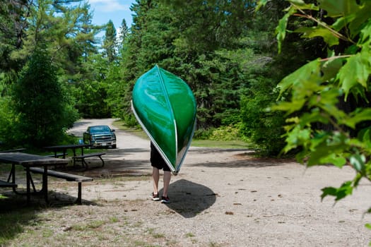 The kayaker carries the kayak to be loaded onto the vehicle