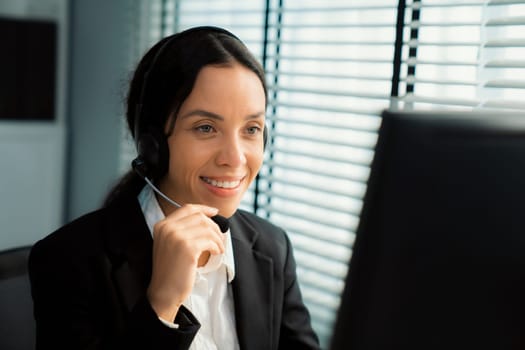 Competent female operator working on computer and talking with clients. Concept relevant to both call centers and customer service offices.