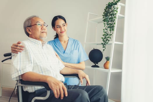 Caring nurse and a contented senior man in a wheel chair at home, nursing house. Medical for elderly patient, home care for pensioners.