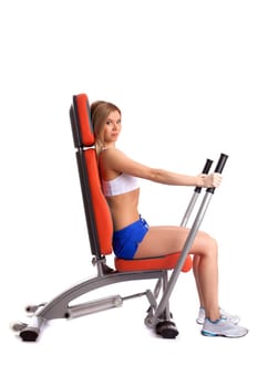 Young slim woman trains on exerciser, isolated on white